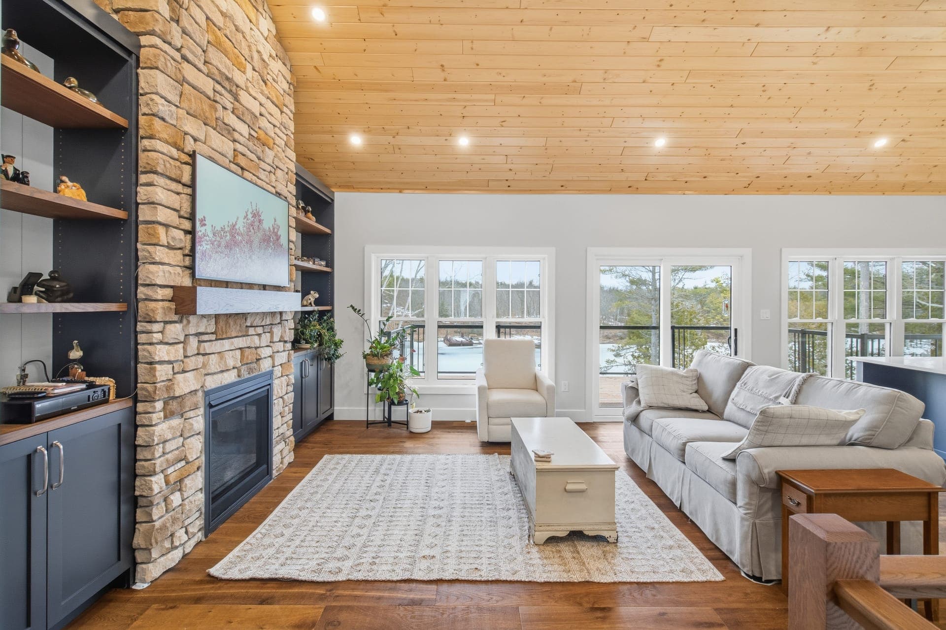 Open concept living space with stone fireplace and natural light
