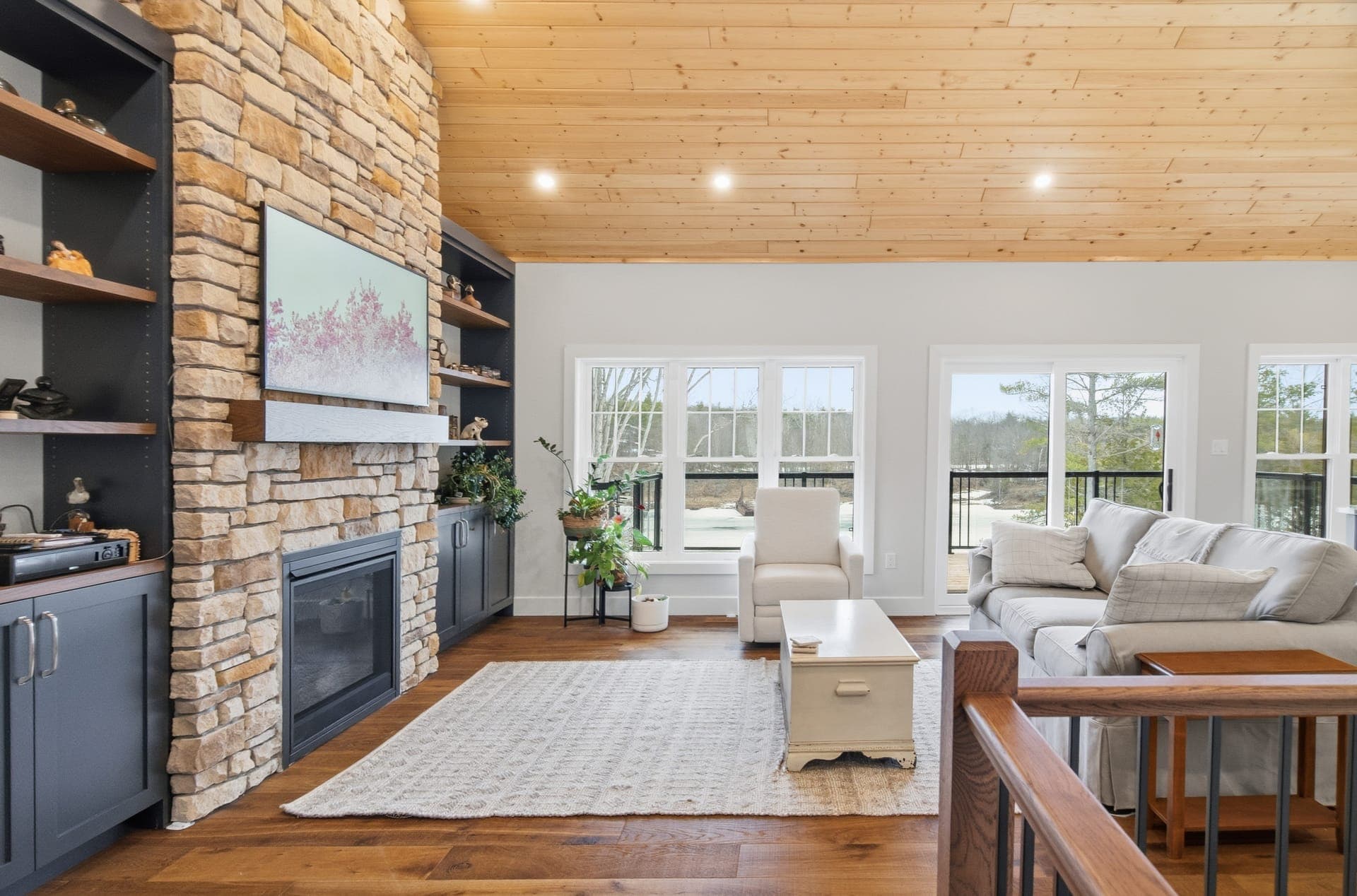 Great room with cathedral wood ceiling and windows to the water